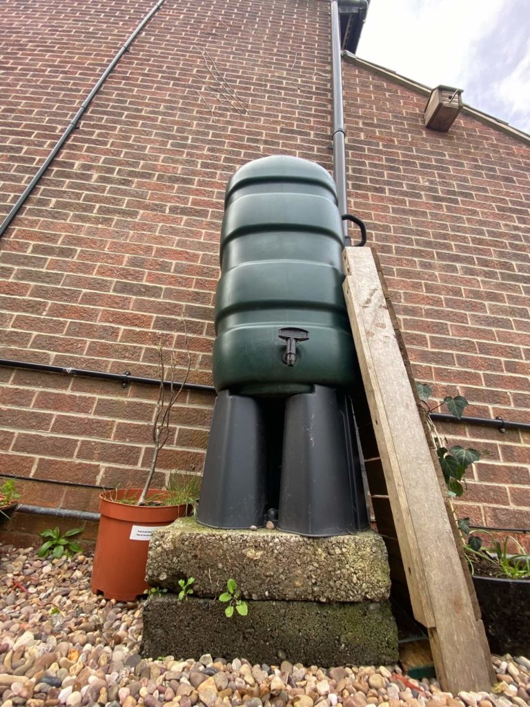 A water butt installed at the side of a house